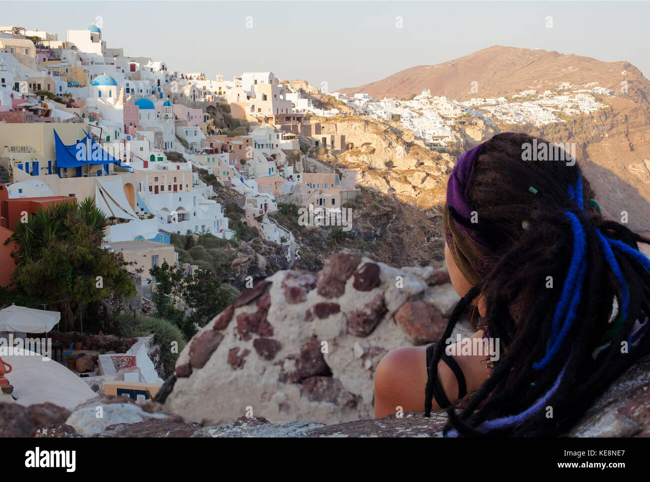 L'île de Santorin, Grèce - 19 juillet 2012 : woman traveler de derrière en regardant incroyable coucher du village d'Oia à Santorin. c'est une île dans le sou Banque D'Images