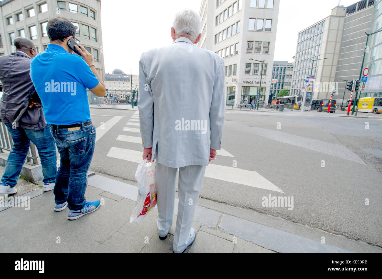 Bruxelles, Belgique. Homme dans un costume blanc en attendant de traverser la route Banque D'Images