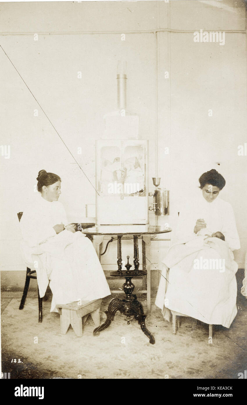 Deux infirmières se nourrir les bébés prématurés dans l'exposition sur l'Incubateur Bébé Pike à la foire mondiale de 1904. La tenue de deux autres nourrissons incubateur sur la table entre eux Banque D'Images