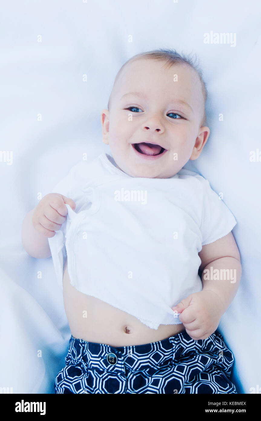 High angle view of smiling baby boy portant sur son dos Banque D'Images