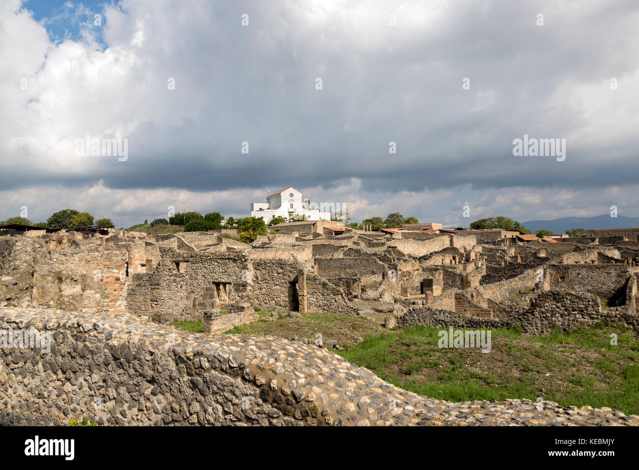 Vue sur les murs des maisons de Pompéi, avec petite église blanche à l'arrière-plan. Banque D'Images