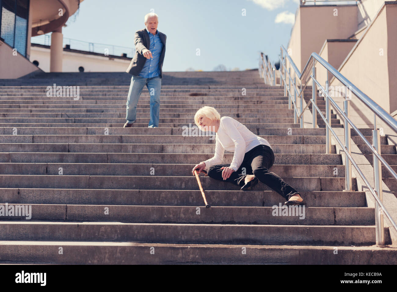 Senior woman tomber en bas de l'escalier Banque D'Images