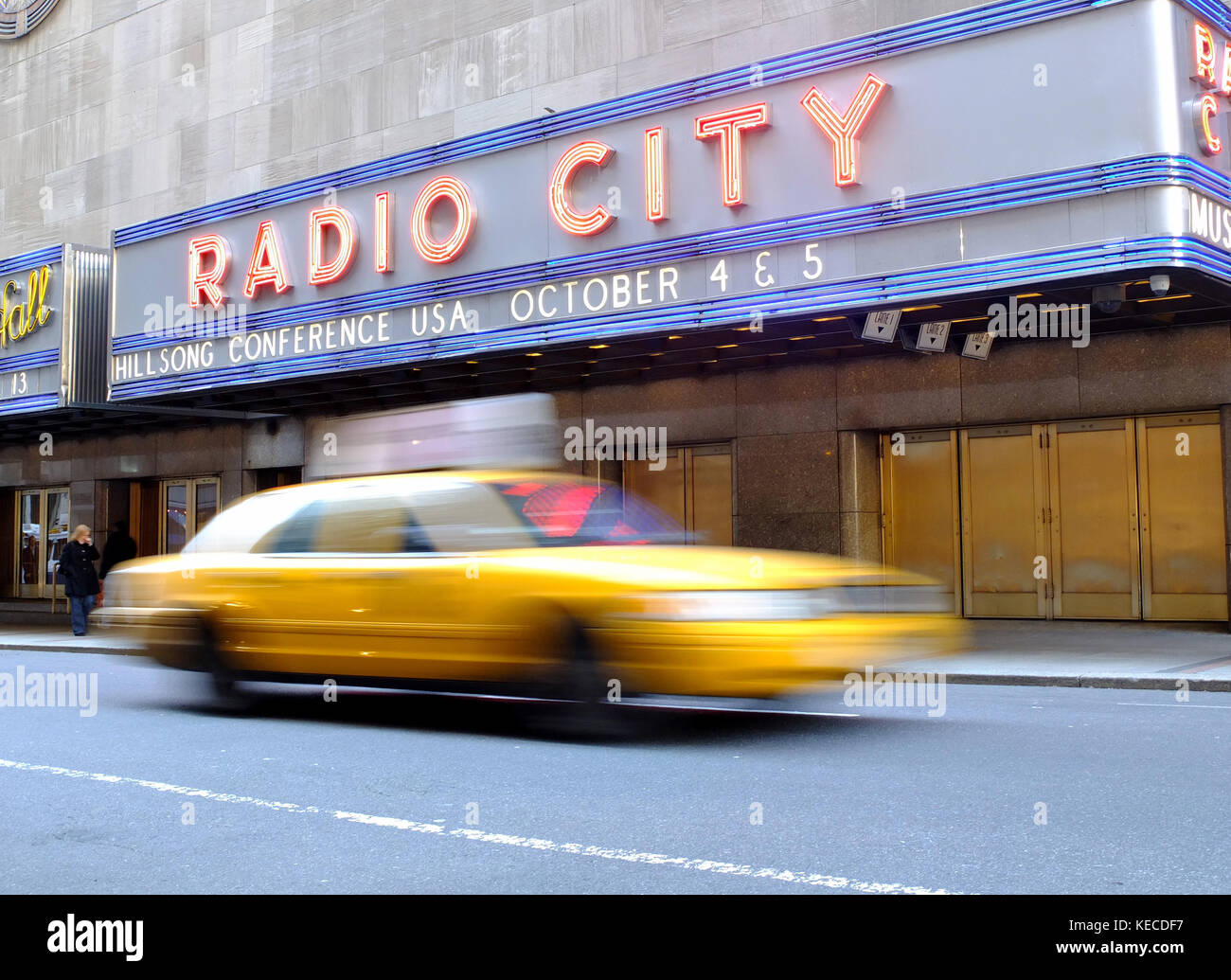 A New York city cab durs passé le Radio City building Banque D'Images