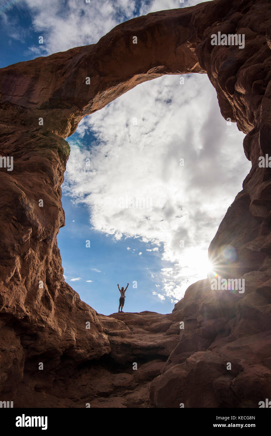 En femme debout dans la tourelle du rétroéclairage arch dans le Arches national park, Utah, USA Banque D'Images