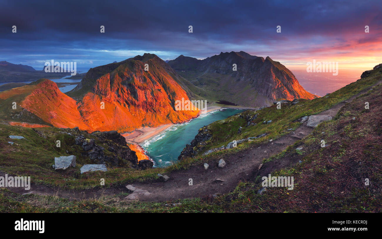 La Norvège l'été au coucher du soleil. soleil rouge s'allumer rock sur la baie pittoresque. Banque D'Images