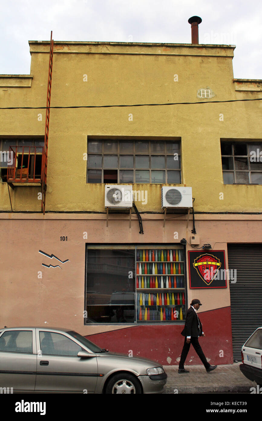 Hommes marchant devant un bâtiment coloré dans le quartier de Poblenou Barcelone, Catalogne, Espagne Banque D'Images