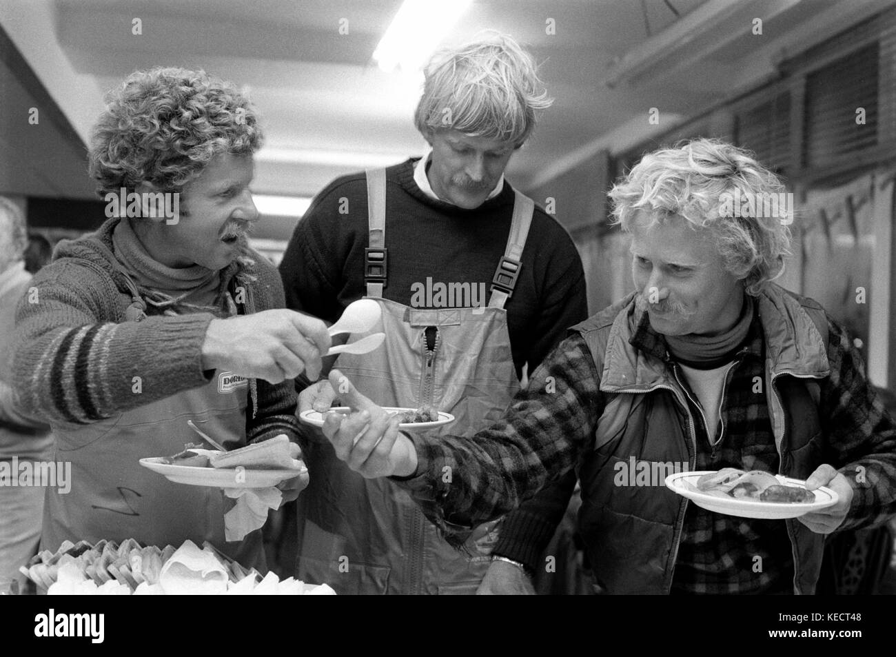 AJAXNETPHOTO. 3OTH MARS 1982. GOSPORT, ANGLETERRE. - FIN DE COURSE DE WHITBREAD - CERAMCO N.Z. LE SKIPPER PETER BLAKE (AU CENTRE) REJOINT LES MEMBRES DE SON ÉQUIPAGE DE YACHT POUR UN PETIT DÉJEUNER TÔT LE MATIN À LA FIN DE LA DERNIÈRE ÉTAPE DE LA COURSE. PHOTO:JONATHAN EASTLAND/AJAX REF:820304 13 Banque D'Images