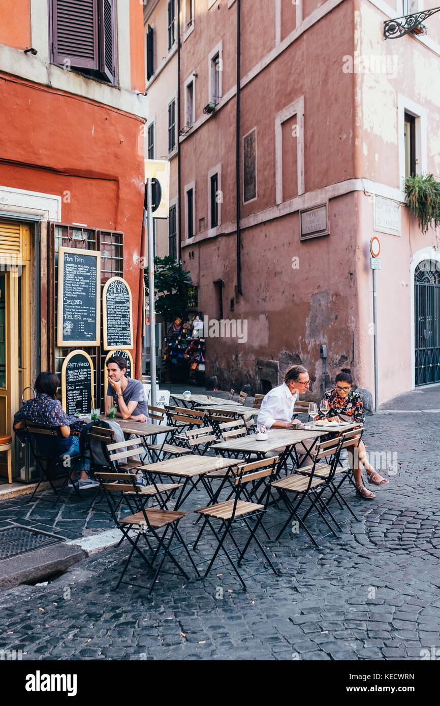 Amis partager un aperitivo (apéritif) à des tables dans un café à Rome, Italie Banque D'Images