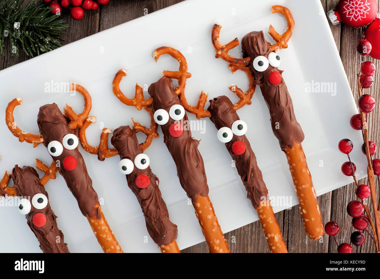 Le renne de noël mignon bretzel au chocolat, les tiges au-dessus sur une assiette de service blanc Banque D'Images