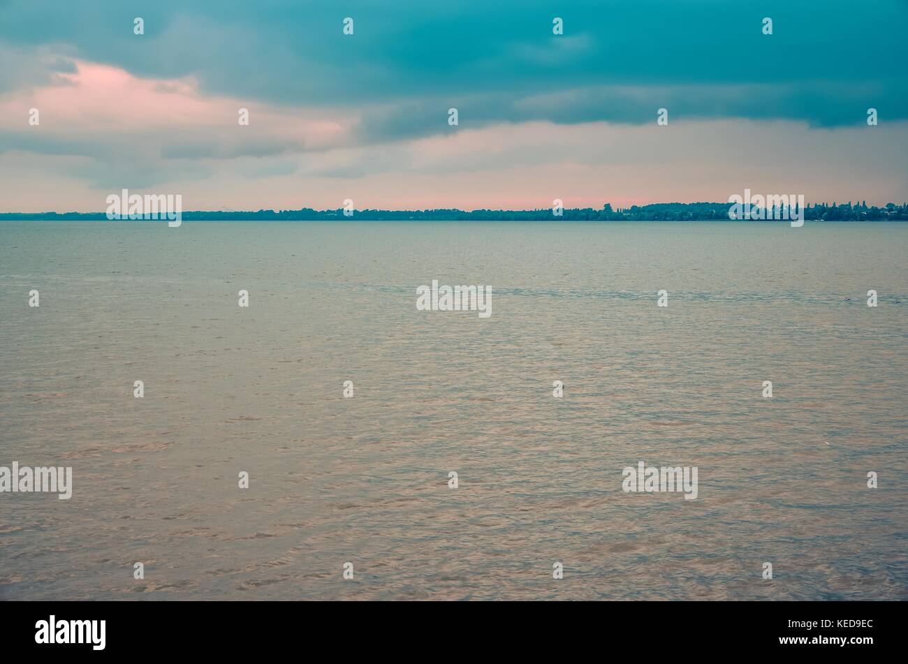 Paysage d'été minimaliste. grand lac avec littoral sur une journée nuageuse. Banque D'Images