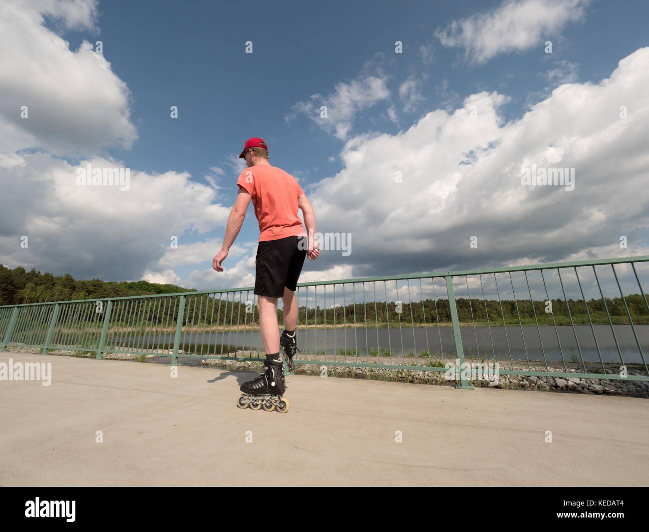 Le patineur de roller en action. man ride en patins à rouler le long de la  main courante de la promenade, ciel bleu en arrière-plan. low angle view  Photo Stock - Alamy