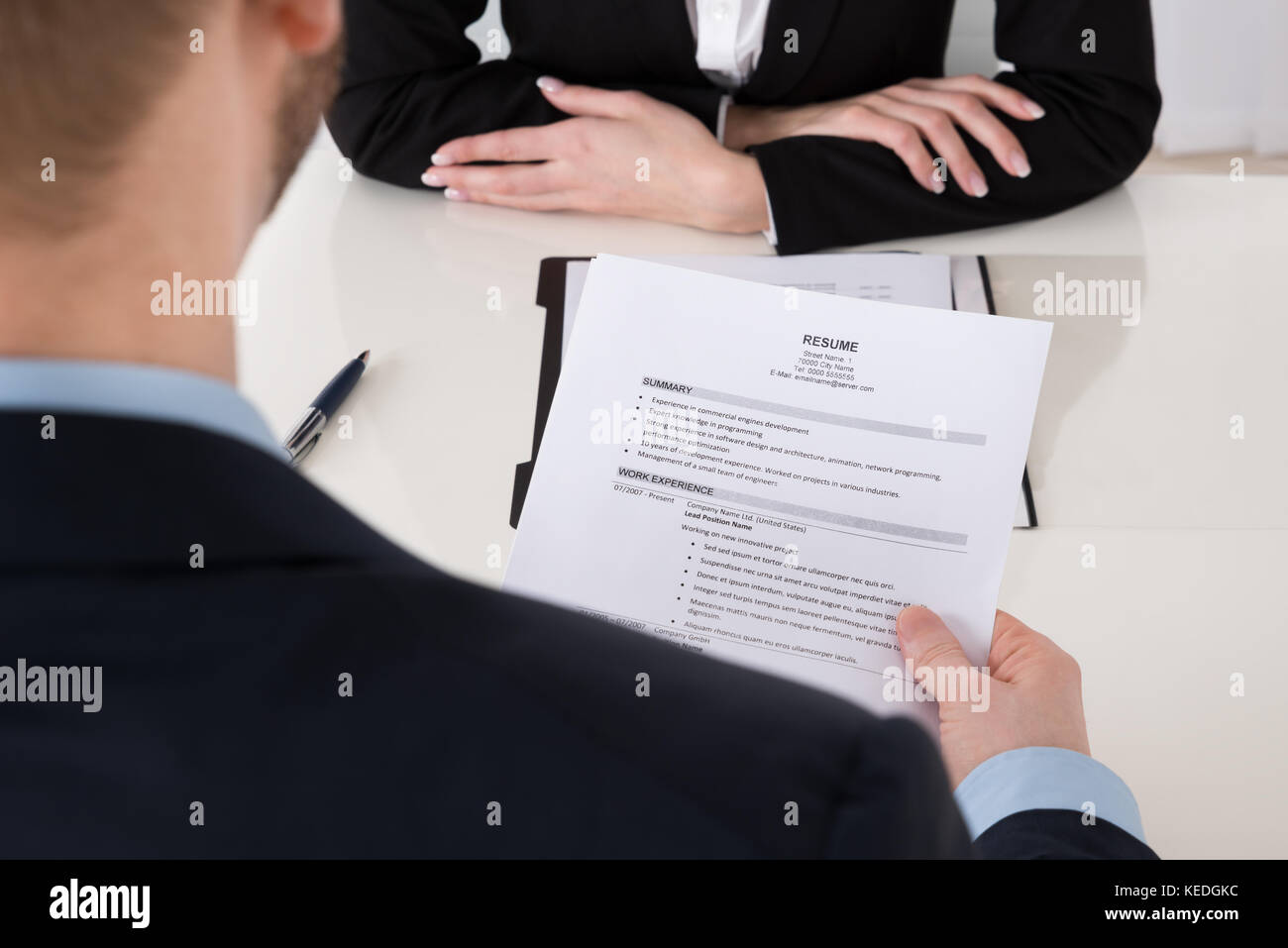 Close-up of young businessman holding reprendre at office desk Banque D'Images