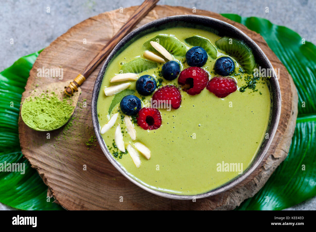 Smoothie matcha vert avec des bleuets, framboises et kiwis Banque D'Images
