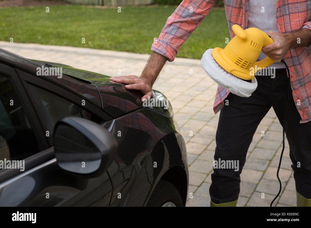Service de nettoyage automatique du personnel masculin une voiture avec brosse de lavage rotative Banque D'Images