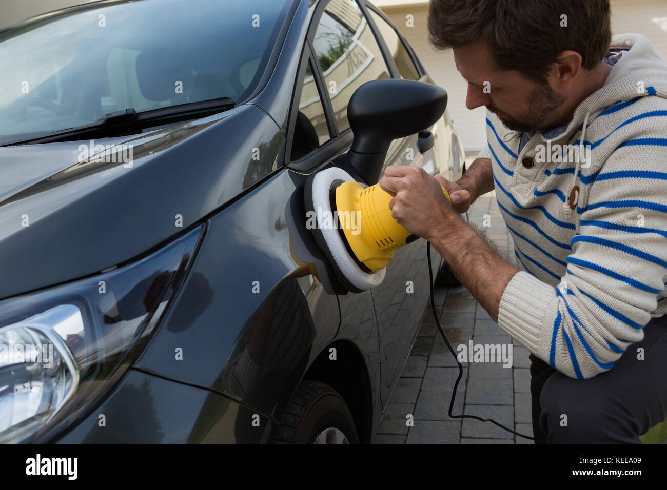 Service de nettoyage automatique du personnel masculin une voiture avec brosse de lavage rotative Banque D'Images