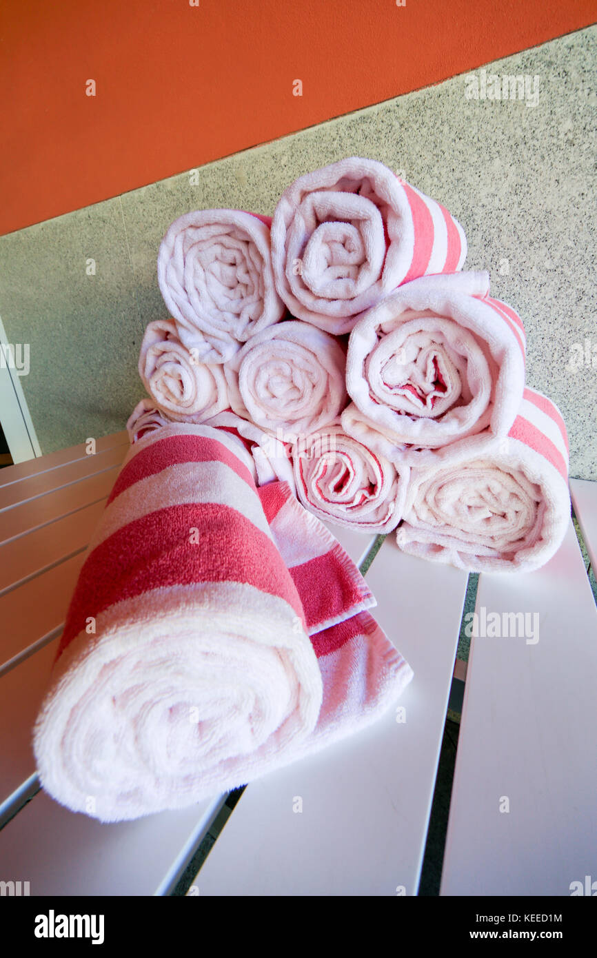 Serviettes de piscine à rayures roses et blanches enroulées dans un pieu Banque D'Images