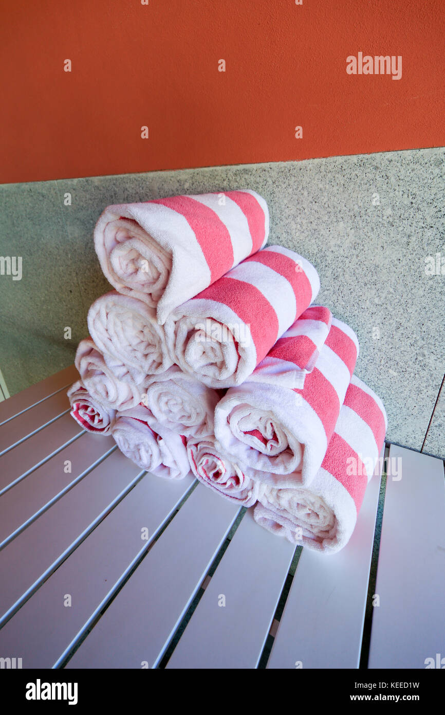 Serviettes de piscine à rayures roses et blanches enroulées dans un pieu Banque D'Images