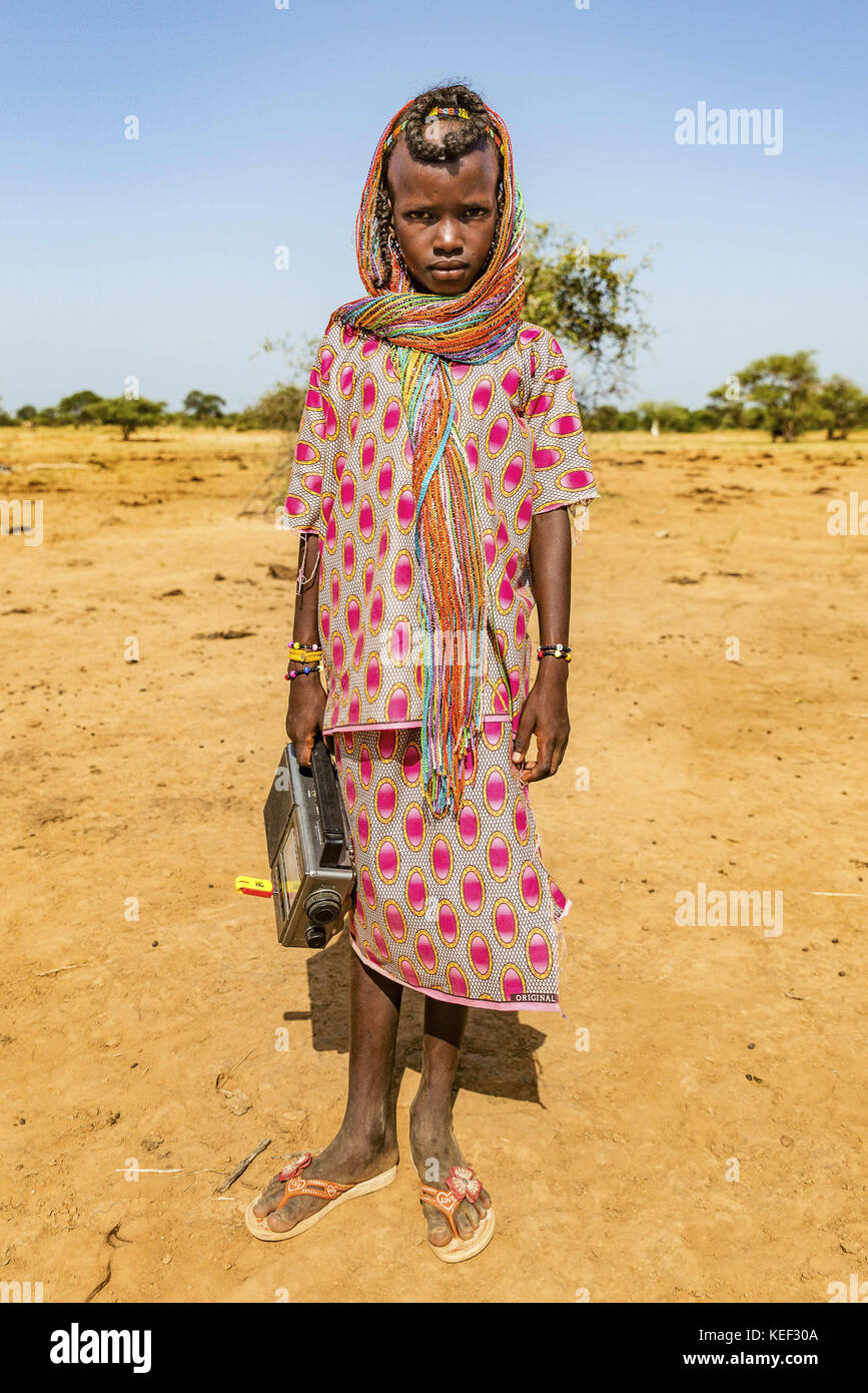 Tchad. 27 septembre 2016. Une jeune fille Wodaabe arrive au festival avec sa radio et une clé USB. Après des mois passés à élever leurs vaches dans le désert dans de petites unités familiales, Gerewol est une chance pour les Wodaabe de se réunir et de rattraper leur retard. Crédit : Tariq Zaidi/ZUMA Wire/Alamy Live News Banque D'Images