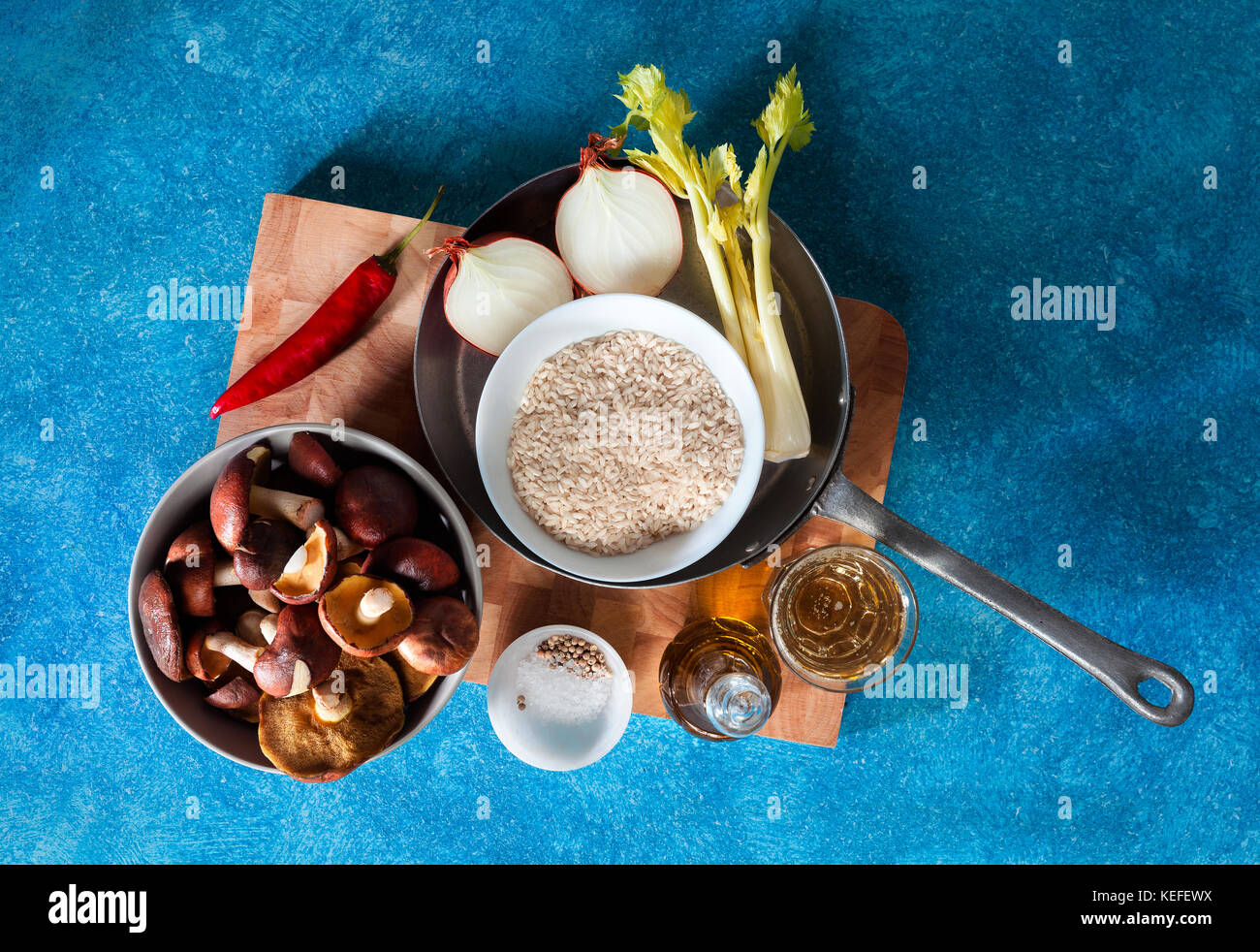 Ingrédients pour le risotto aux champignons frais sur un fond bleu Banque D'Images