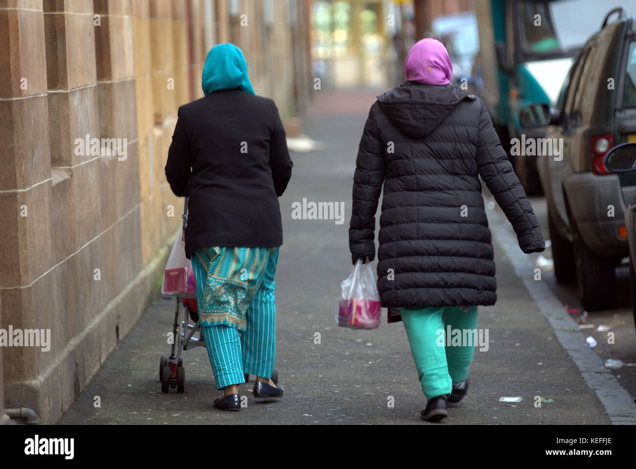 Étrangers asiatiques pakistanais marchant dans la rue dans les hijabs Govanhill, Glasgow, Royaume-Uni Banque D'Images