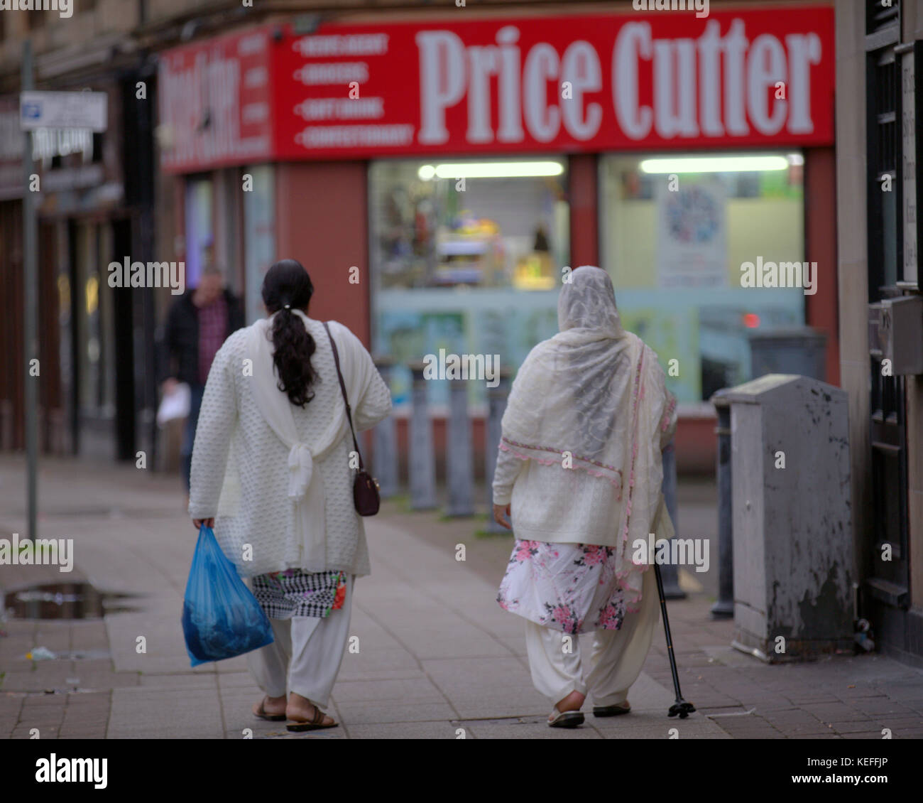 Étrangers asiatiques pakistanais marchant dans la rue dans les hijabs Govanhill, Glasgow, Royaume-Uni Banque D'Images