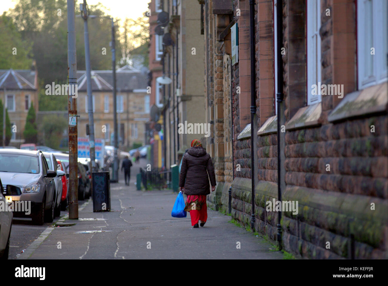 Étrangers asiatiques pakistanais marchant dans la rue dans les hijabs Govanhill, Glasgow, Royaume-Uni Banque D'Images