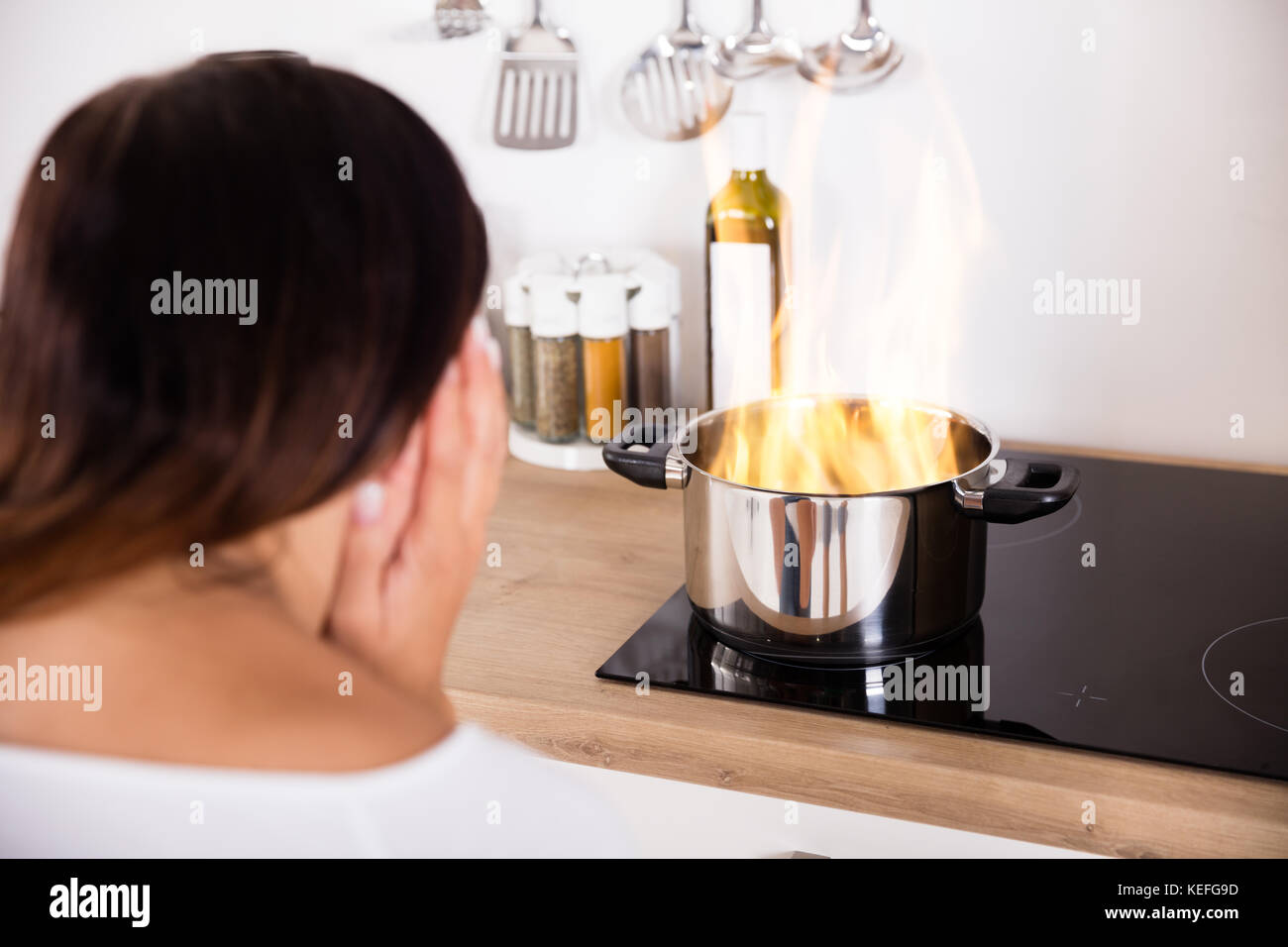 Choqué Woman Cooking pot au feu près de gaz dans la cuisine moderne Banque D'Images