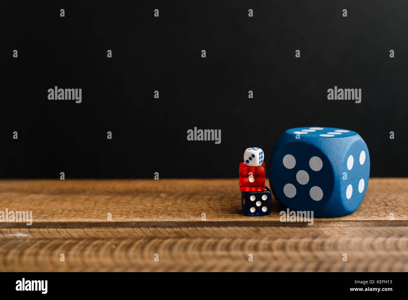 Dés sur une table en bois noir en arrière-plan. Banque D'Images