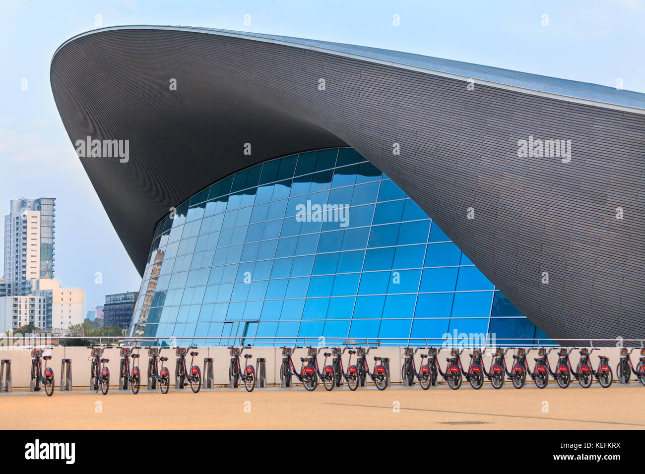 Le Centre aquatique extérieur, par Zaha Hadid, une moderne salle de sport avec rangée de vélos de ville en face du Parc Olympique Queen Elizabeth, Stratford, Lon Banque D'Images