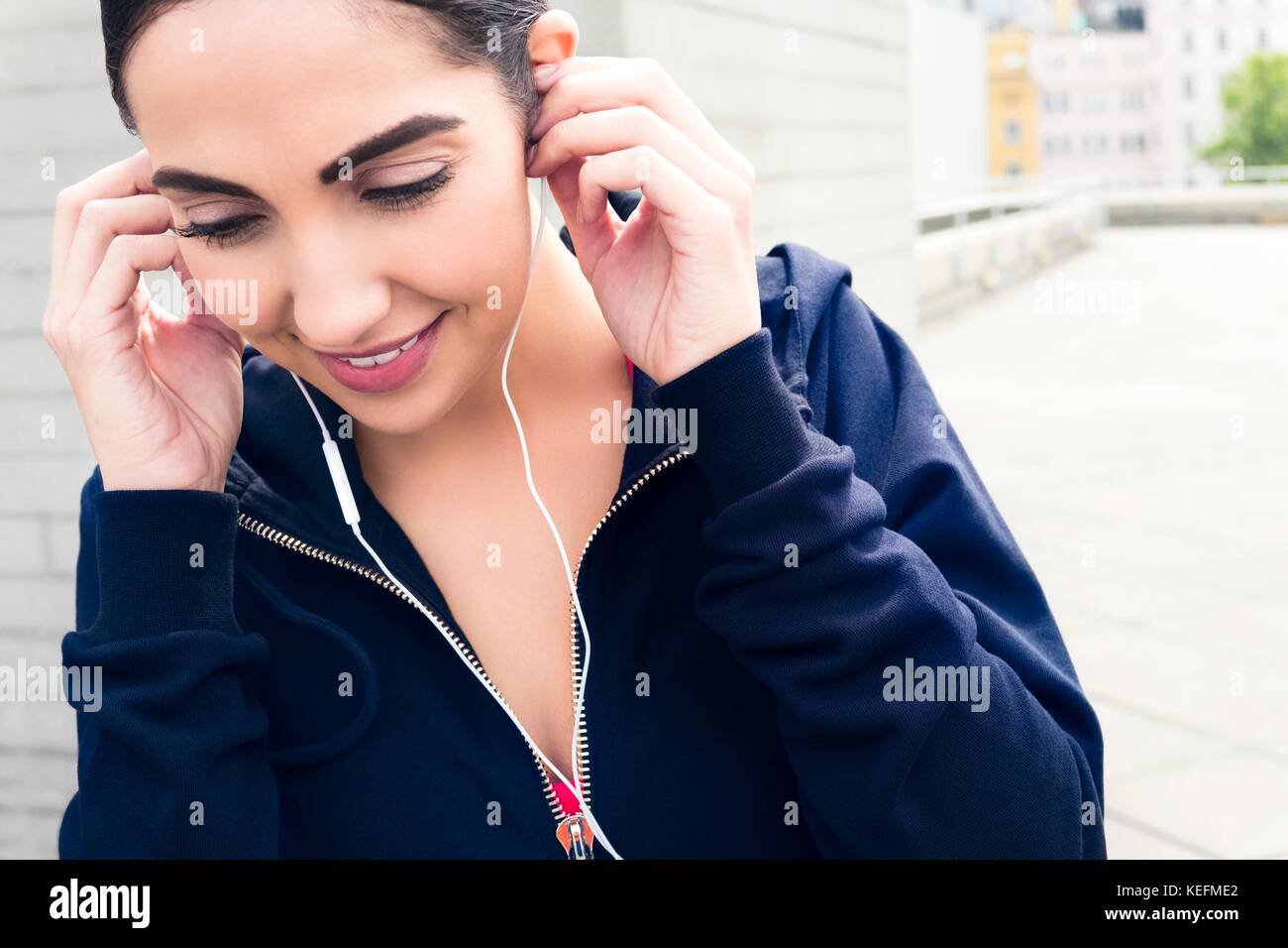 Parution du modèle. Jeune femme portant des écouteurs, souriant. Banque D'Images