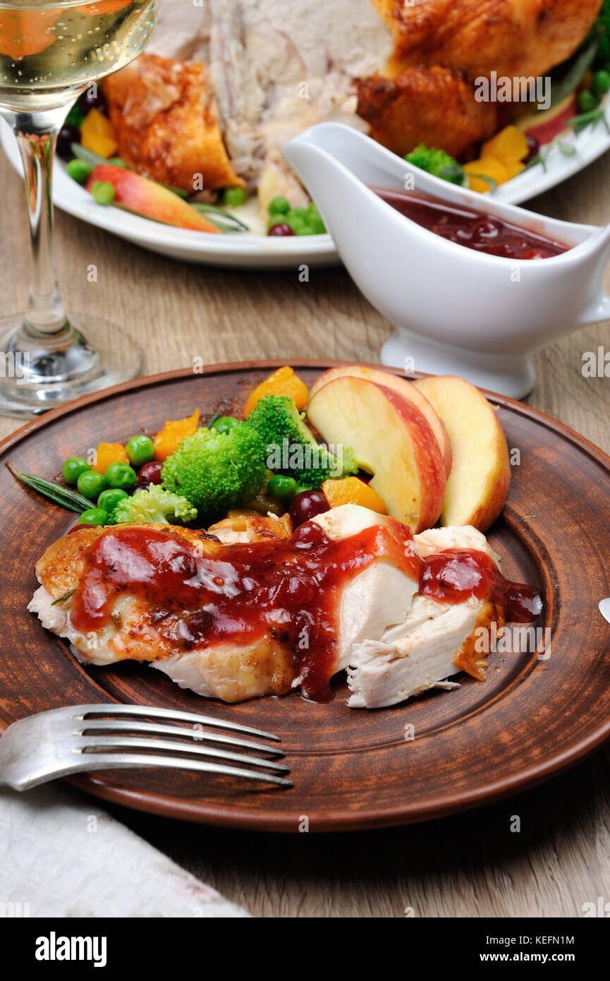 Tranches de dinde cuite au four avec sauce aux canneberges et à l'orange avec la garniture de légumes et fruits Banque D'Images