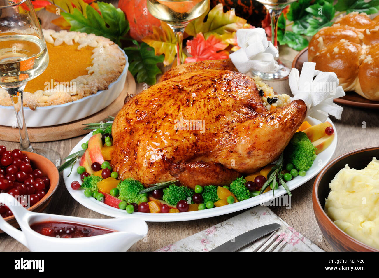 La Turquie au four avec légumes, tarte au potiron, purée de pommes de terre, pains à l'ail et la sauce aux canneberges et à l'orange sur la table le dîner le jour de Thanksgiving Banque D'Images