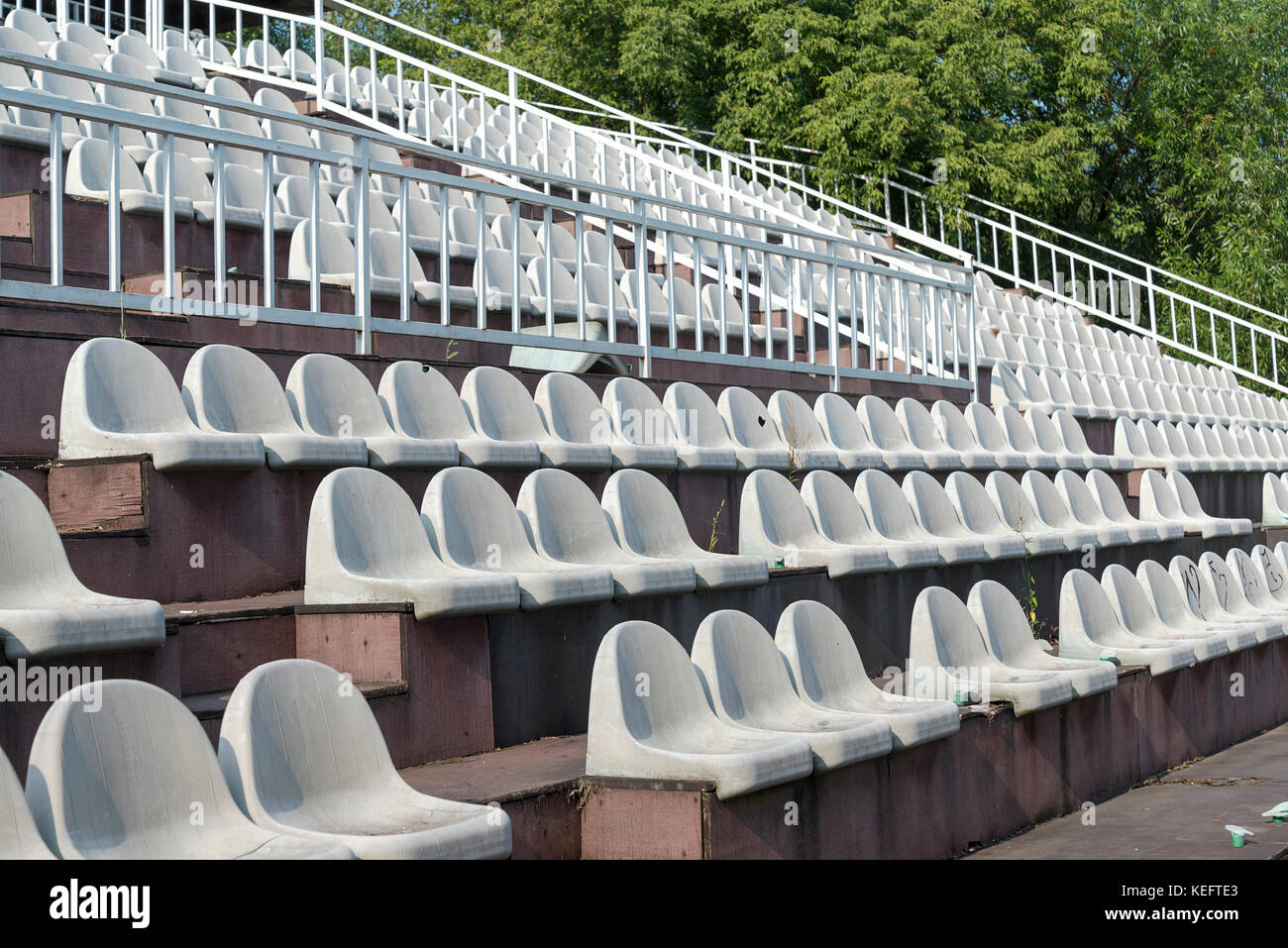 Chaises gris dans les gradins de l'arène un jour d'été. Banque D'Images