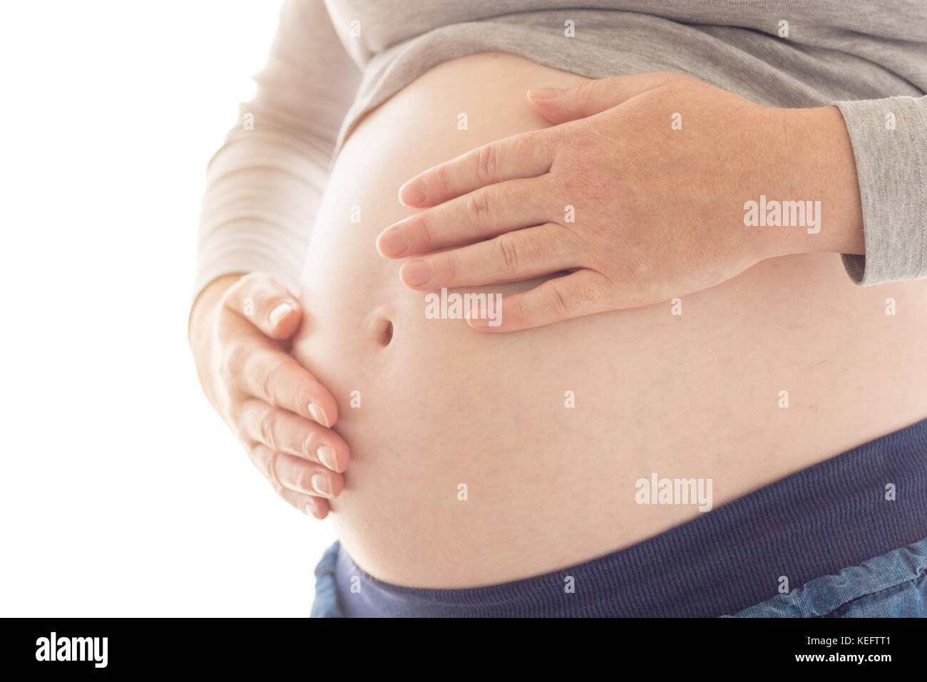 Pregnant woman touching et frottant son ventre, mère de caresser et de stimuler l'abdomen, des profils portrait féminin en cinquième mois ou vingt première semaine de Banque D'Images