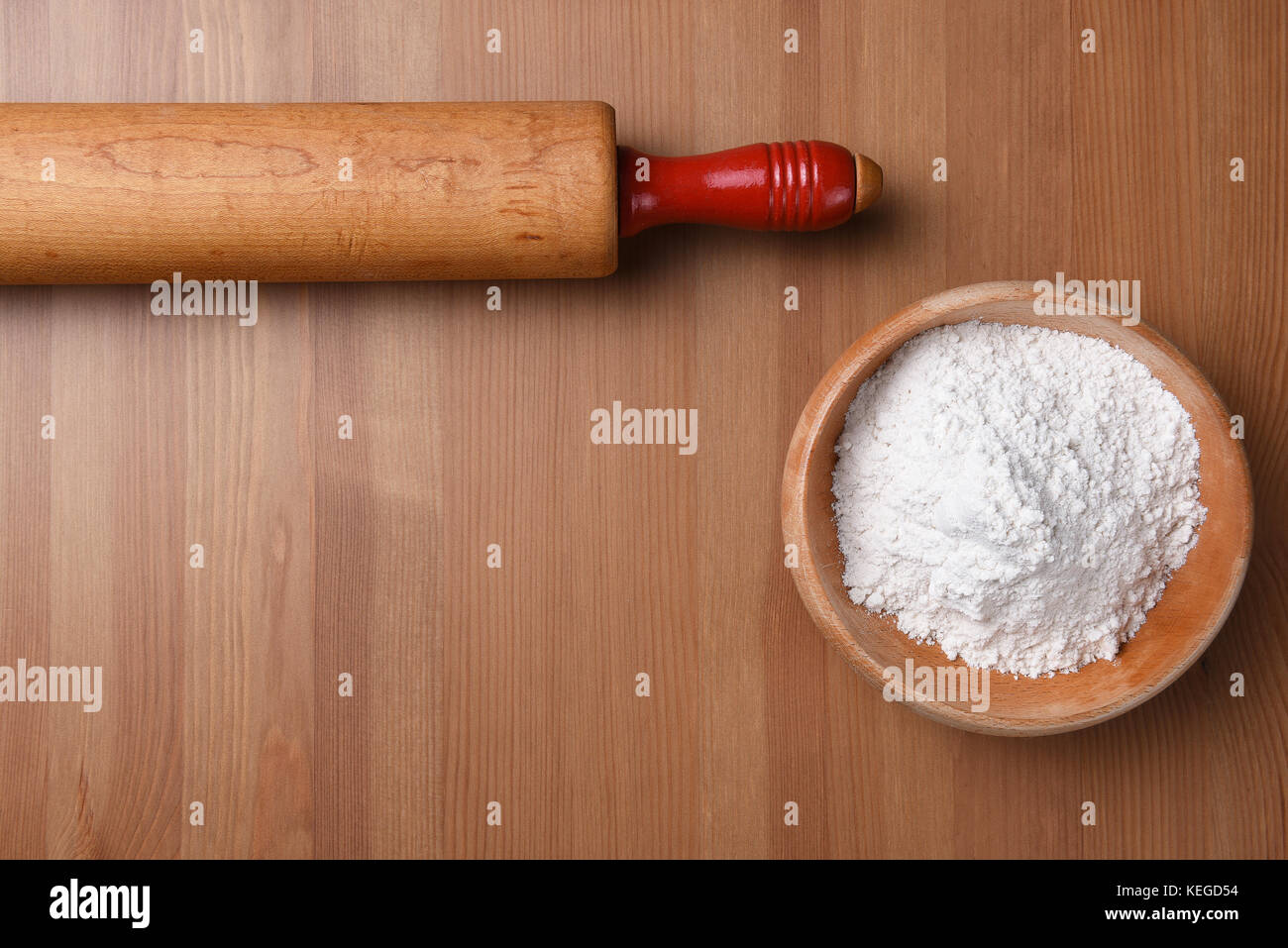 Vue de dessus d'un rouleau à pâtisserie et le bol de farine sur un fond en bois avec l'exemplaire de l'espace. Banque D'Images