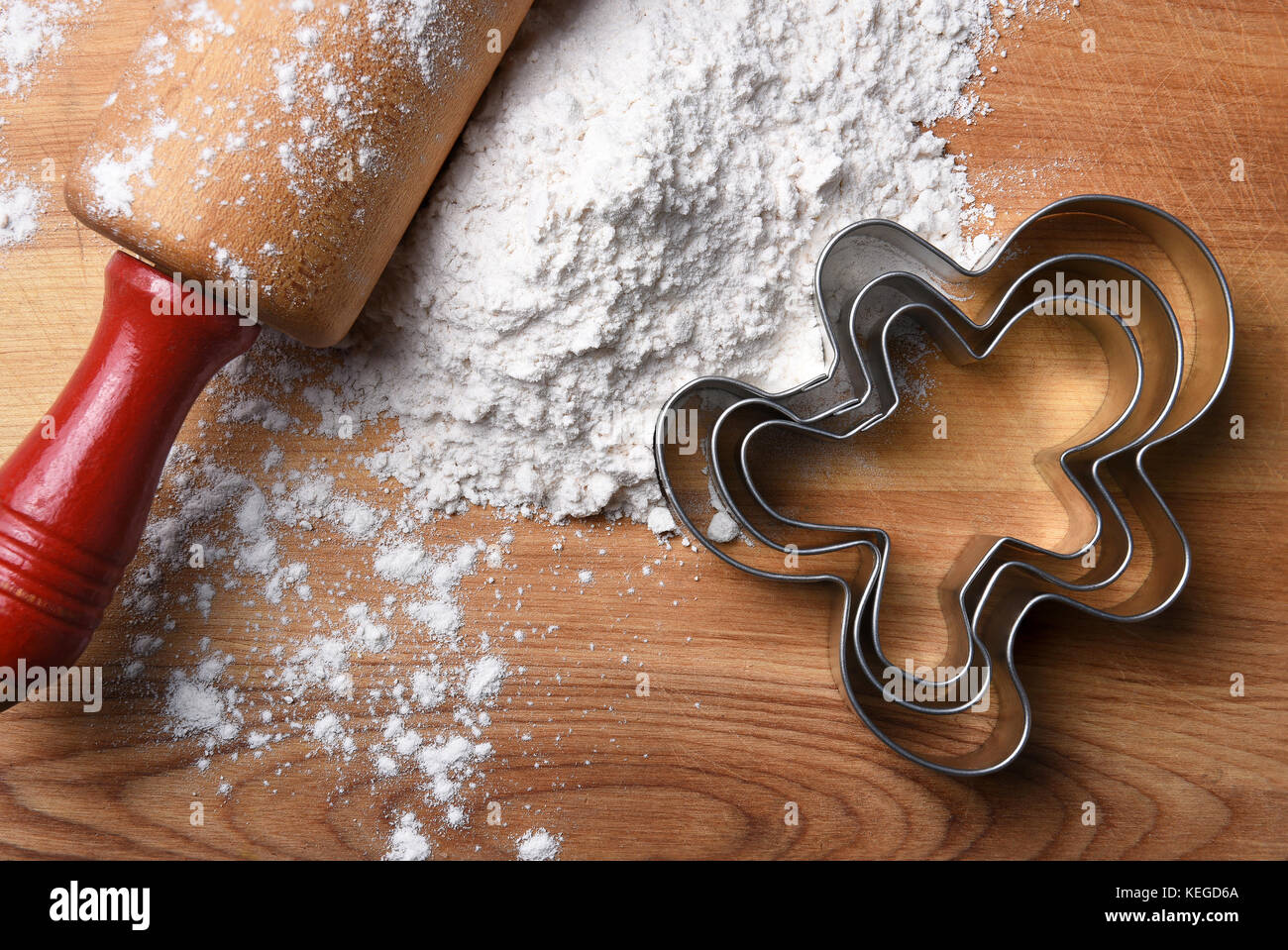 Vue de dessus gros plan d'un rouleau à pâtisserie sur une planche à découper, la farine et le gingerbread man emporte-pièce. Banque D'Images