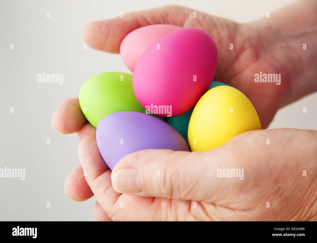 Un homme tenant plusieurs œufs de Pâques colorés Banque D'Images
