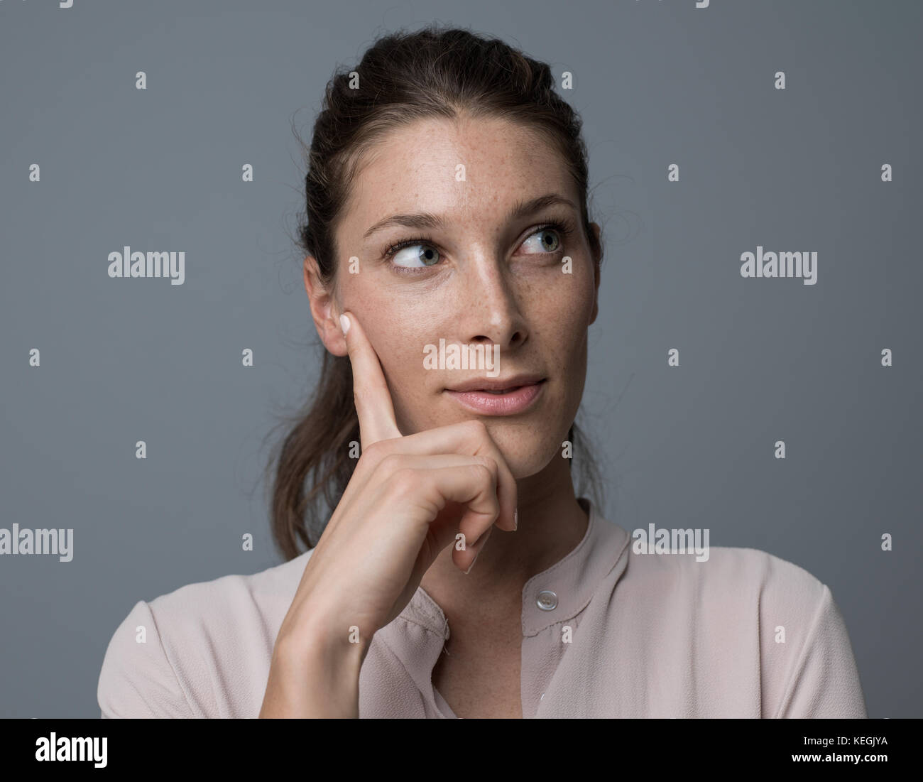 Woman thinking with hand on chin, elle est la planification et la prise de décisions Banque D'Images Woman thinking with hand on chin, elle est la planification et la prise de décisions Banque D'Images
