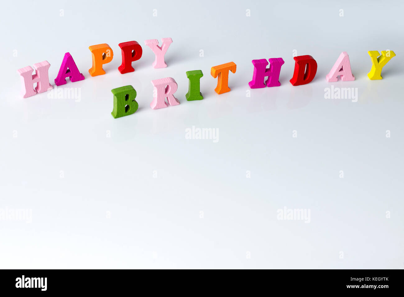 Le mot joyeux anniversaire sur fond blanc de lettres multicolores. Banque D'Images