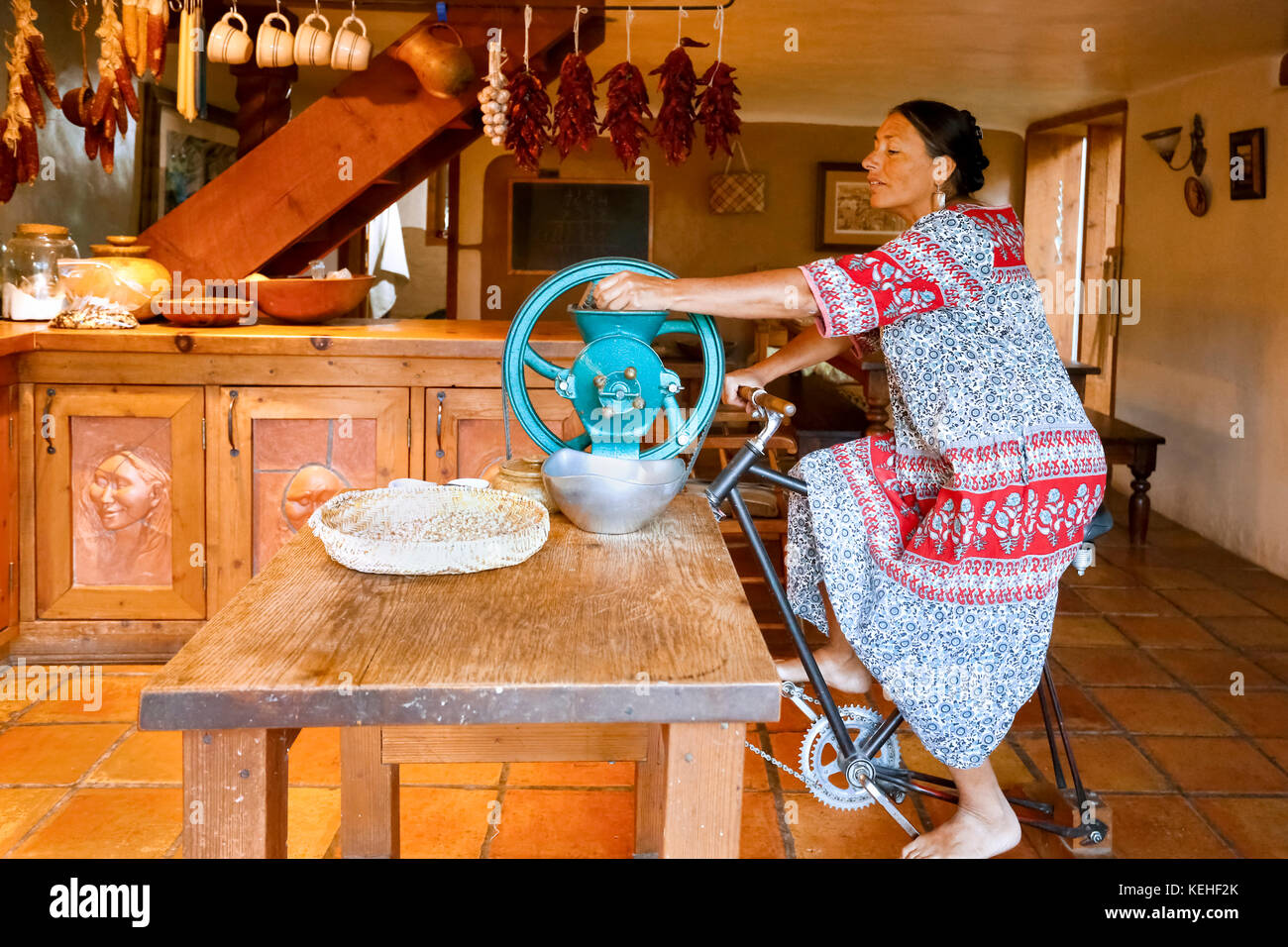 Femme qui fait du vélo pour le moulin à café dans la cuisine Banque D'Images