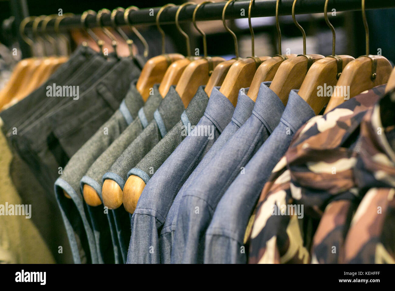 Chemises et pantalons suspendus sur le porte-vêtements dans le magasin de détail Banque D'Images