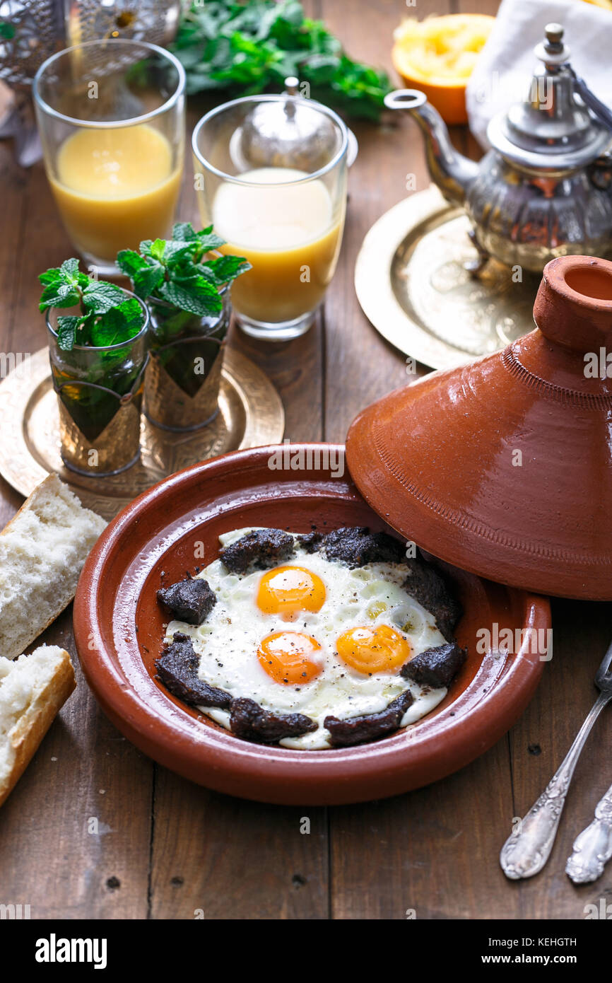 Sunnyside œufs cuits dans un plat à tajine boeuf, petit-déjeuner marocain  avec du jus de fruit et thé à la menthe Photo Stock - Alamy