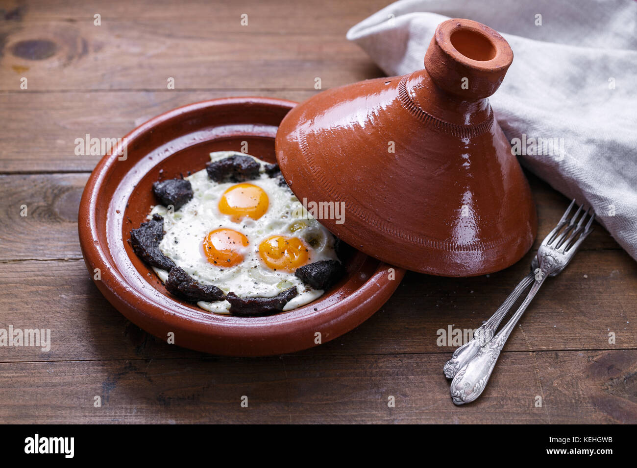 Fermer la vue d'œuf frit et de boeuf dans un plat tajine, plat traditionnel marocain. Banque D'Images