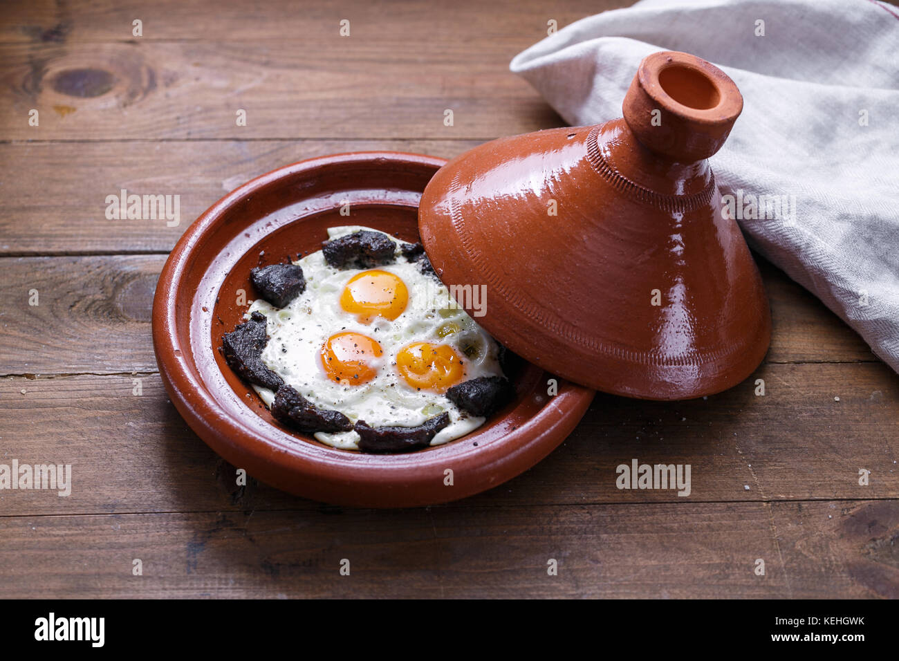 Fermer la vue d'œuf frit et de boeuf dans un plat tajine, plat traditionnel marocain. Banque D'Images
