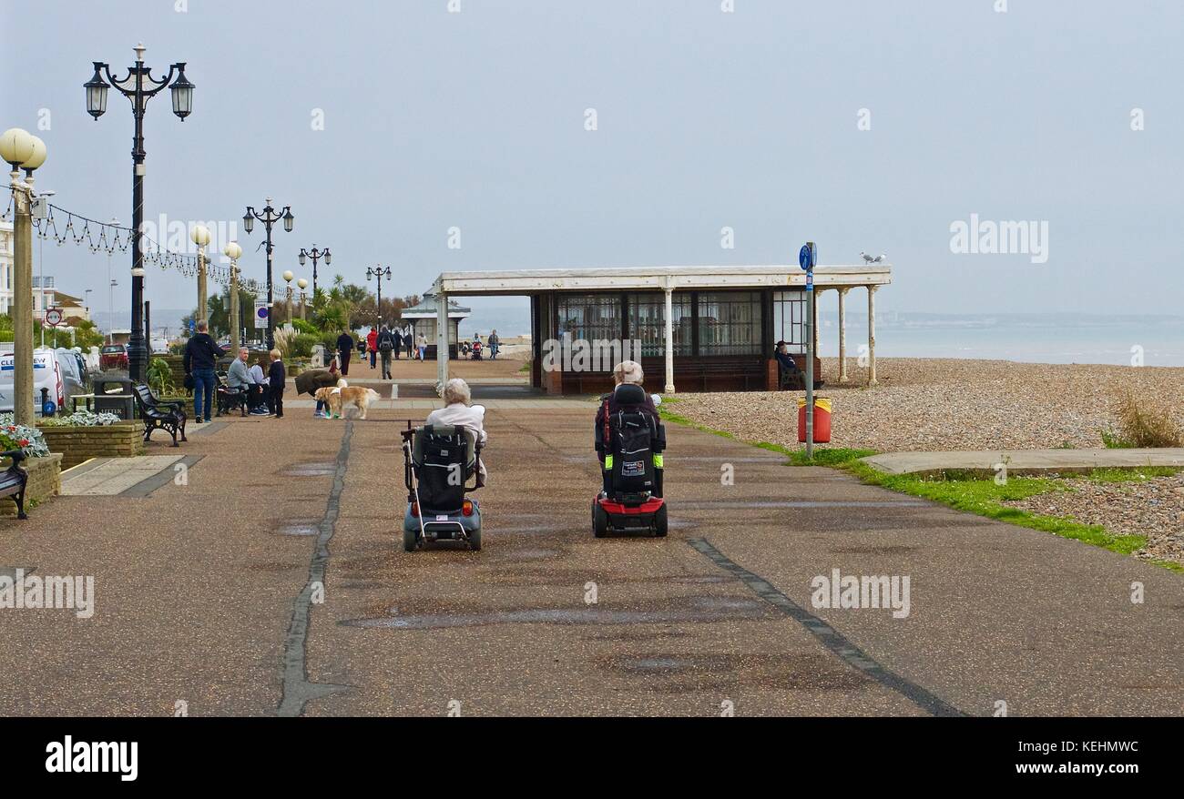 Deux dames âgées sur des scooters de mobilité sur la promenade, Worthing, Royaume-Uni Banque D'Images