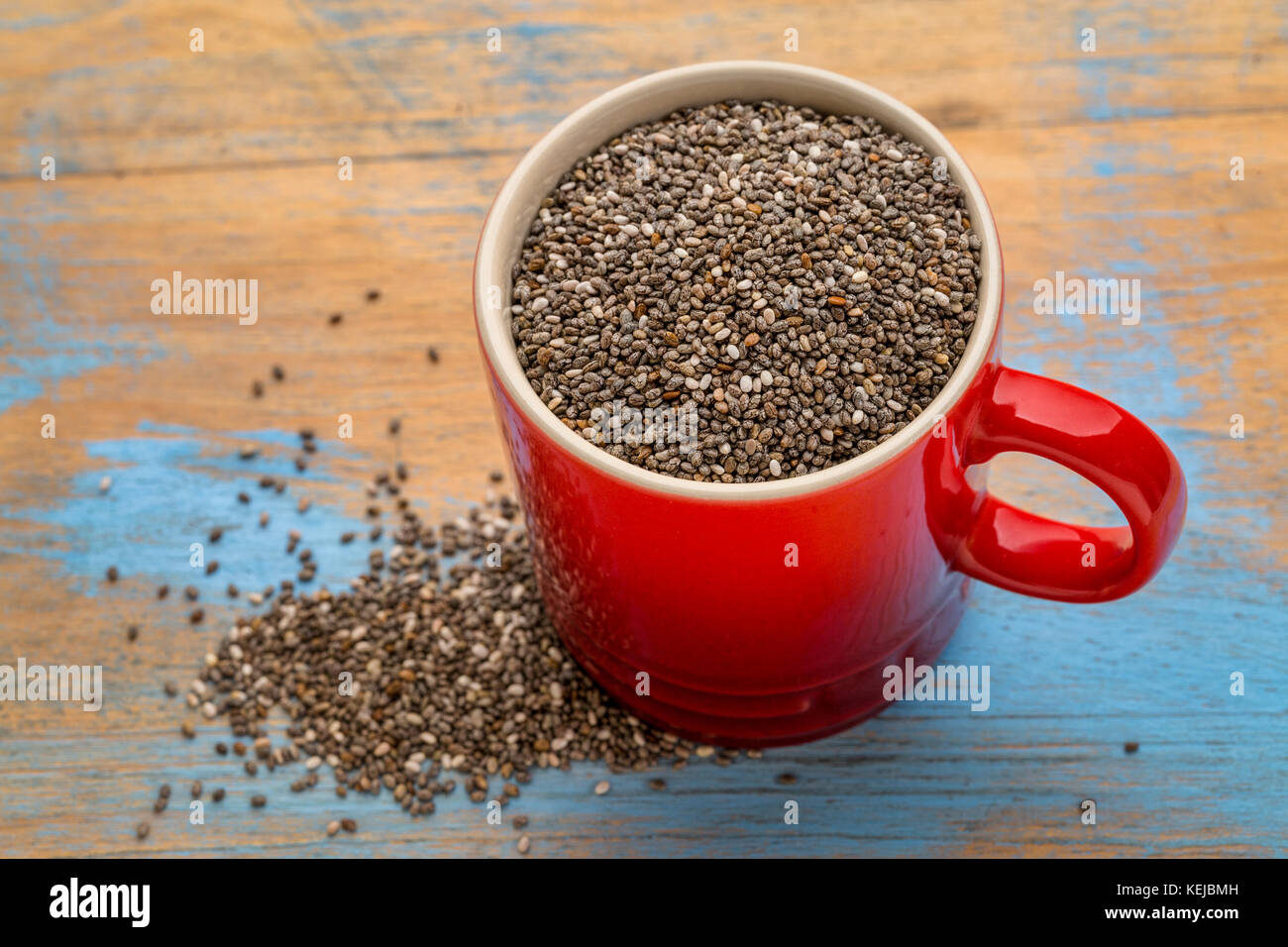 Les graines de chia noir dans une petite tasse à café en grès Banque D'Images