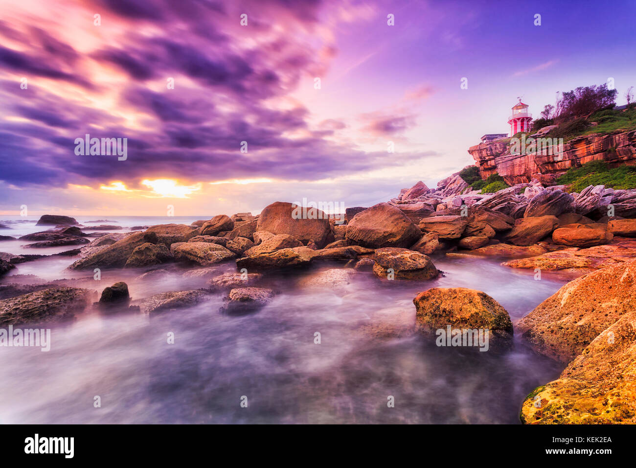 Lever du soleil en bord de mer près de South Head, à l'entrée dans le port de Sydney avec Hornby phare sur une falaise face à soleil levant sur l'océan Pacifique. Banque D'Images