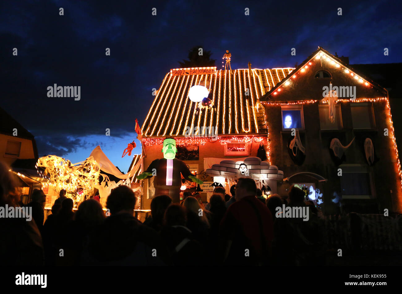 Hamm, Allemagne. 21 octobre 2017. Les visiteurs jettent un coup d'œil à la maison dite d'halloween de Gerd Willenberg à Hamm, en Allemagne, le 21 octobre 2017. Sa maison a été décorée avec des figures effrayantes pour Halloween depuis neuf ans. Jusqu'au 1er novembre, têtes réduites, squelettes et morts-vivants marchent pour effrayer les visiteurs. Crédit : INA Fassbender/dpa/Alamy Live News Banque D'Images