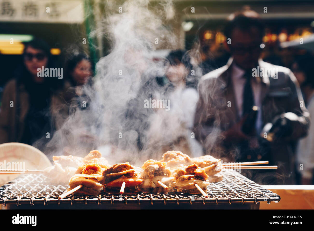 Fruits de mer grillés et de pétoncles mer ​​Urchin oeufs broche avec la fumée, de l'alimentation de rue japonais au marché aux poissons de Tsukiji, Japon. focus sélectif et insert. Banque D'Images