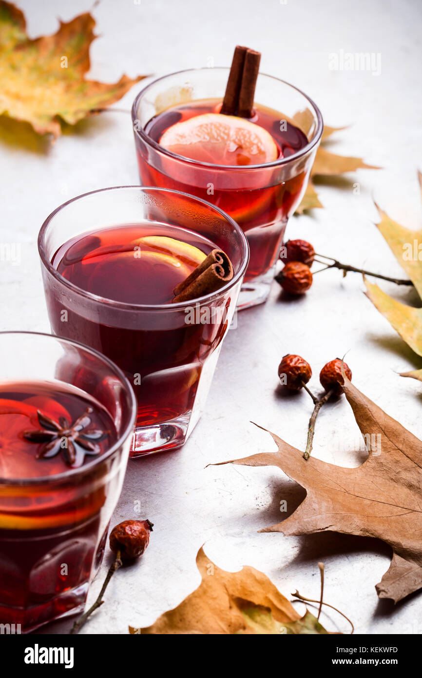Thé rouge chaud avec du citron sur table gris clair avec copie espace, automne délicieux vin chaud verre Banque D'Images